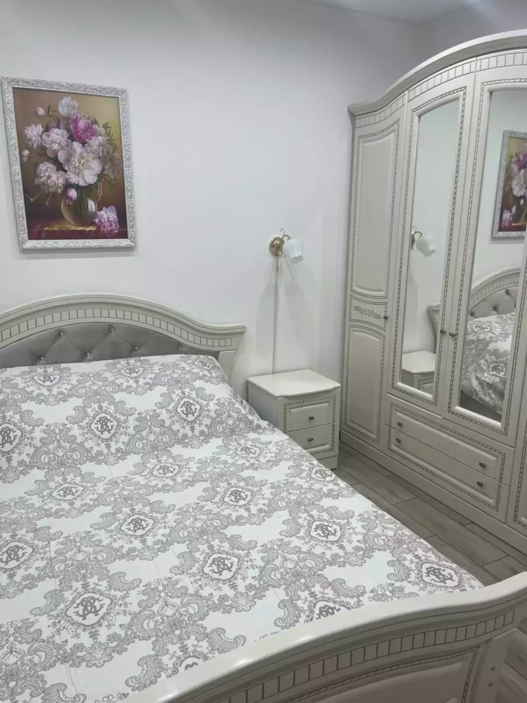 Шкаф и двуспальная кровать белого цвета.